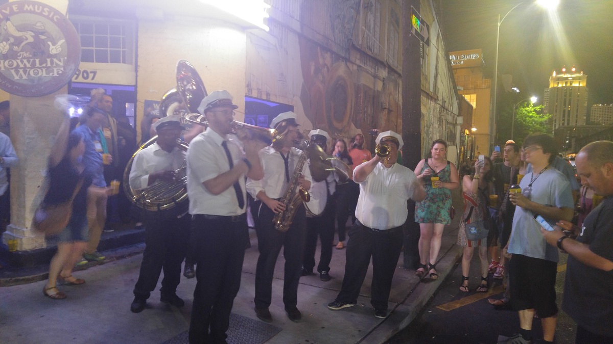 Brass Band on New Orleans street surrounded by crowd taking photos