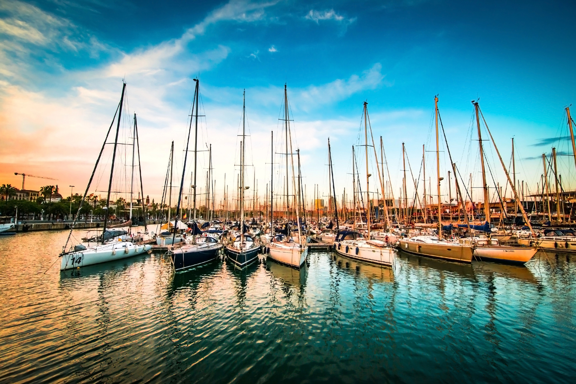 Sailboats in a harbour. All the sails are down.